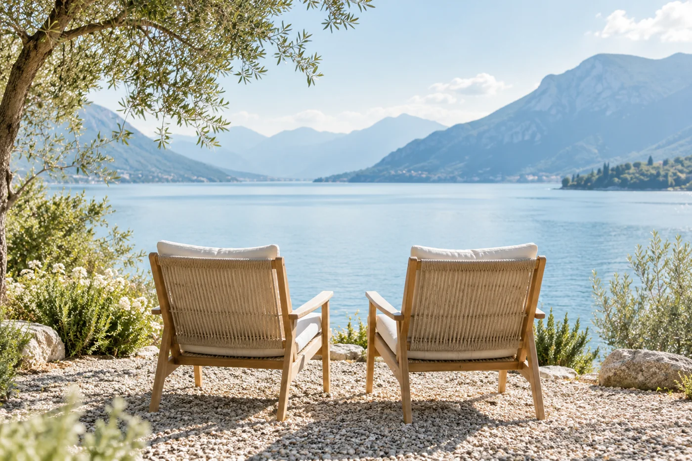 Two empty seats side by side facing a calm pale blue lake